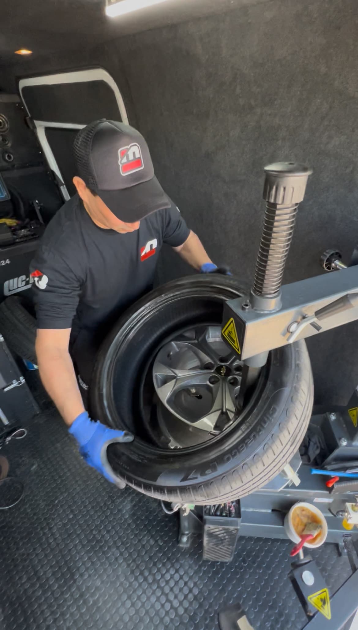 Interior de Sprinter con técnico trabajando en balanceadora móvil - Taller móvil completo