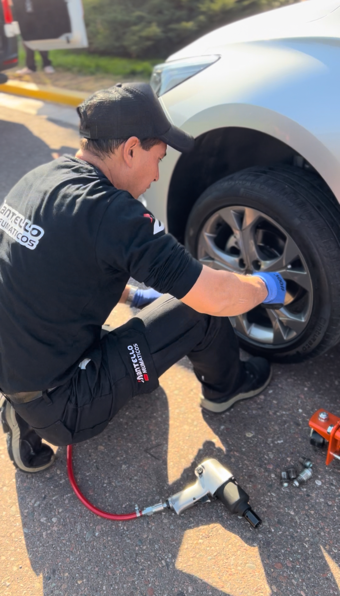 Técnico Mantello realizando instalación de neumático a domicilio con herramientas profesionales