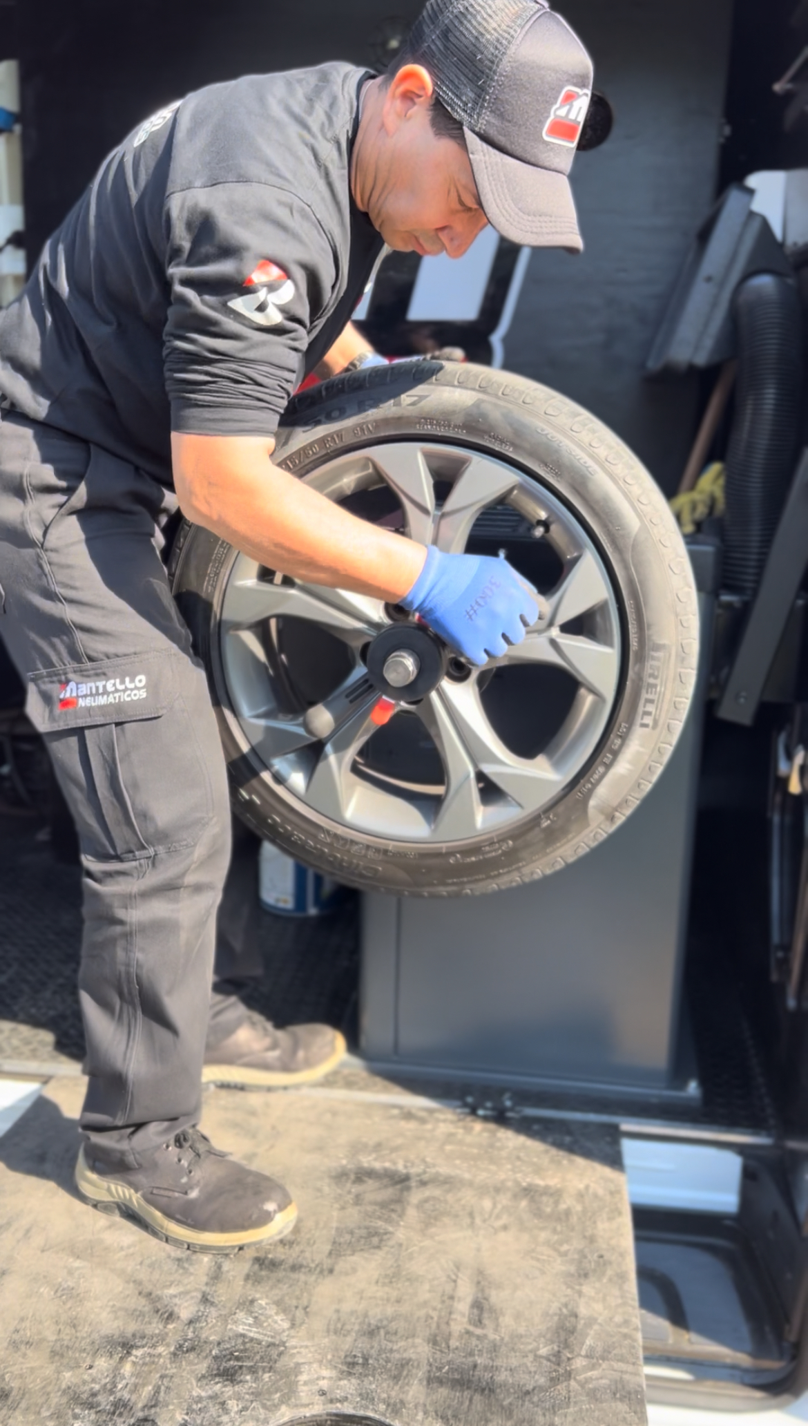 Técnico Mantello operando balanceadora profesional con neumático - Equipamiento móvil de precisión