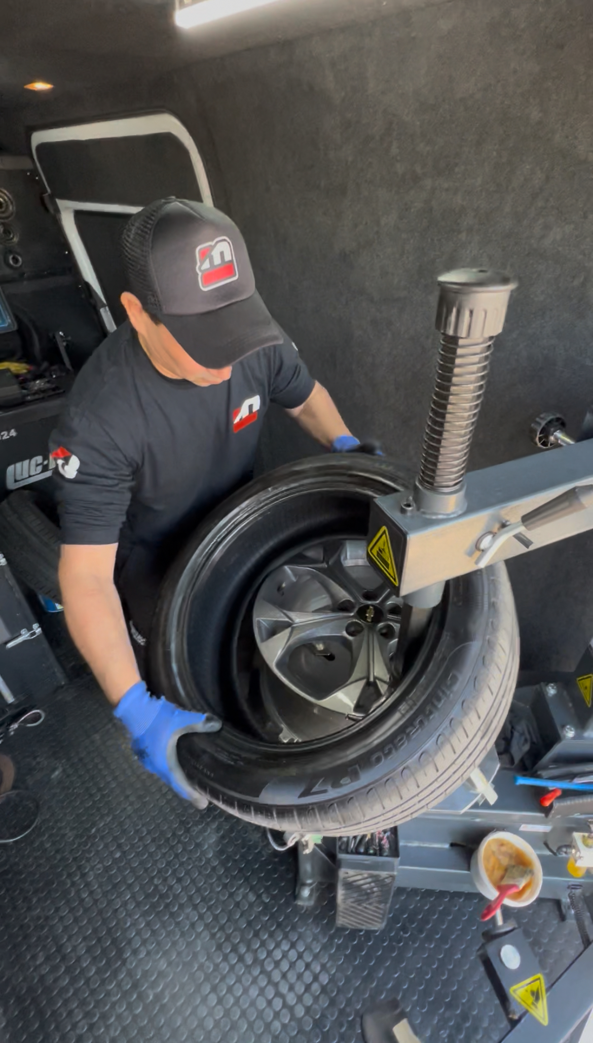 Interior de Sprinter con técnico trabajando en balanceadora móvil - Taller móvil completo